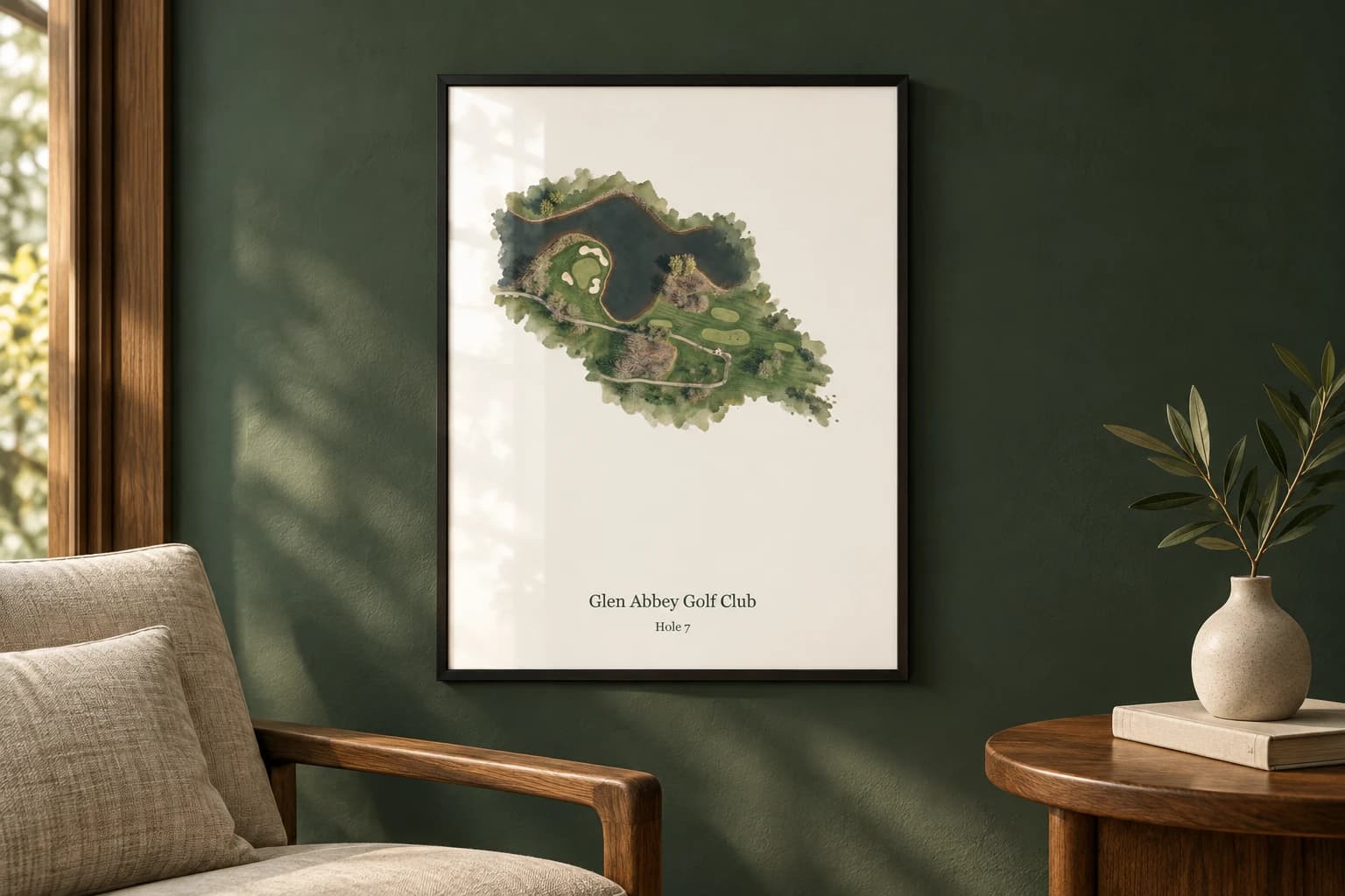Glen Abbey hole 7 in a black frame on a racing-green wall, with a linen chair and timber table